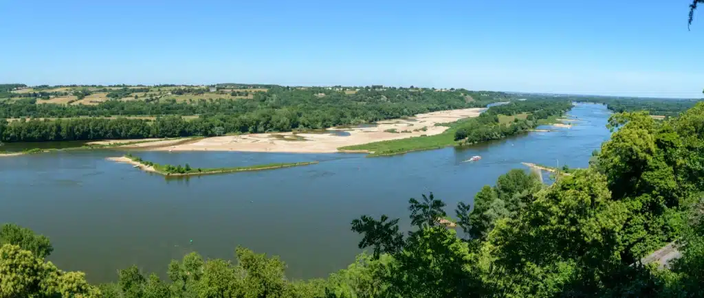 Vue panoramique de la Loire avec ses rives verdoyantes et plages naturelles, offrant un cadre idyllique pour des vacances en gîte dans la région Pays de la Loire.